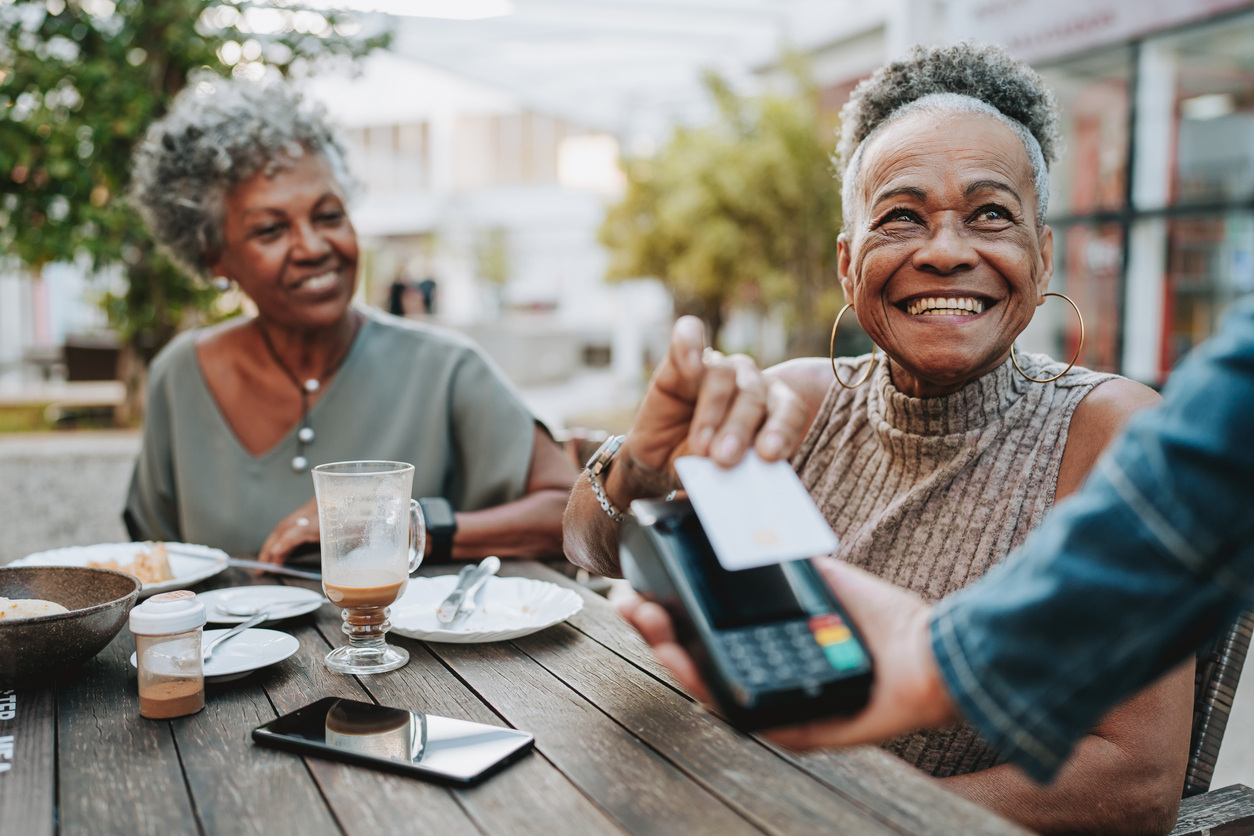 Two women paying for their coffee with a credit card